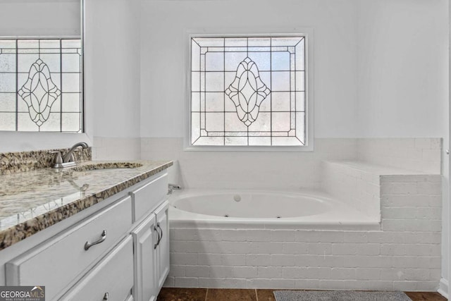 full bath featuring a whirlpool tub and vanity