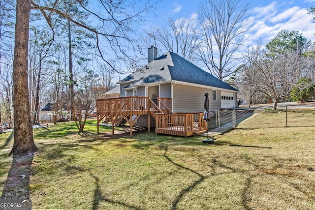 exterior space with a deck, an attached garage, fence, a yard, and a chimney