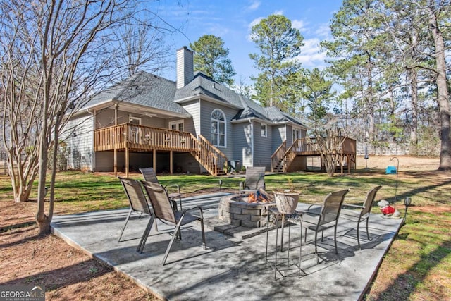 back of property featuring a deck, a fire pit, a patio, and stairway