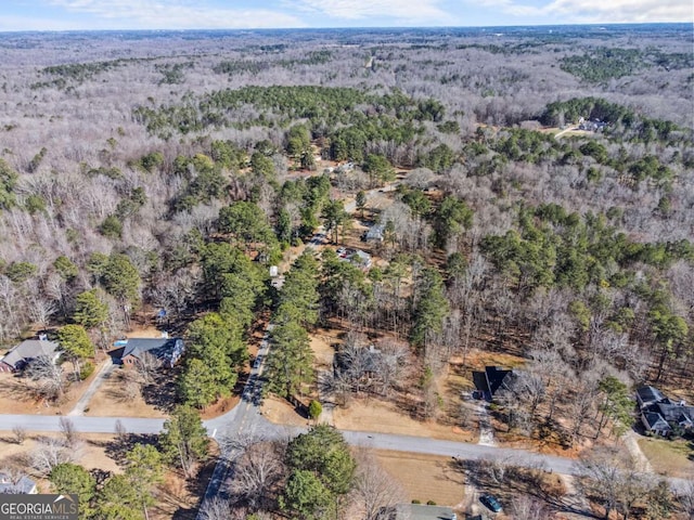 drone / aerial view with a wooded view