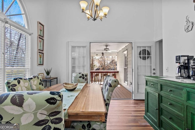 dining room featuring a notable chandelier, a high ceiling, and wood finished floors