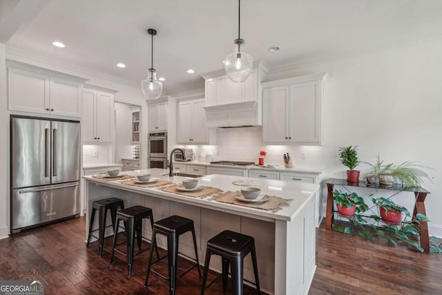 kitchen featuring stainless steel appliances, dark wood-type flooring, a sink, light countertops, and backsplash