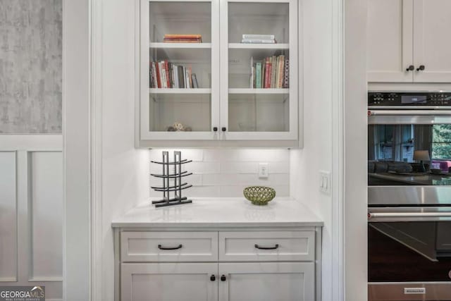 bar featuring tasteful backsplash and double oven