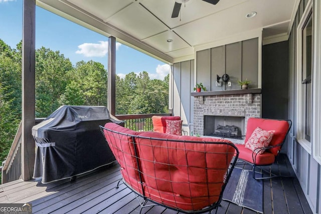 deck with a grill, ceiling fan, and an outdoor living space with a fireplace