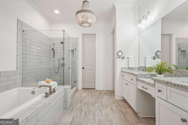 full bath featuring a garden tub, a shower stall, ornamental molding, and vanity