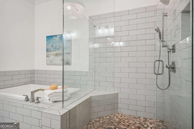 bathroom featuring a stall shower and a bath