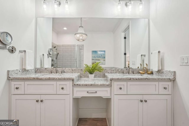 bathroom featuring a tile shower and vanity