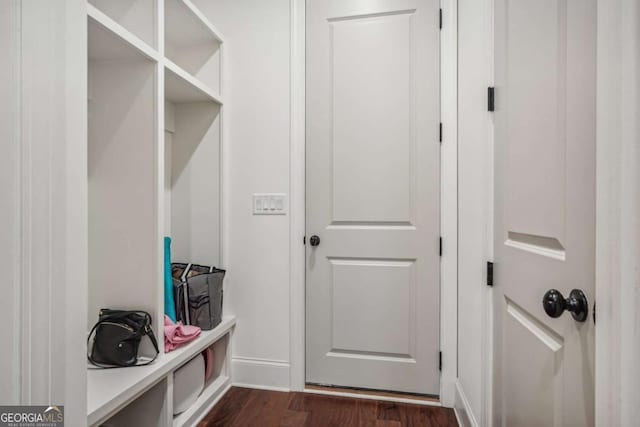 mudroom featuring dark wood finished floors and baseboards