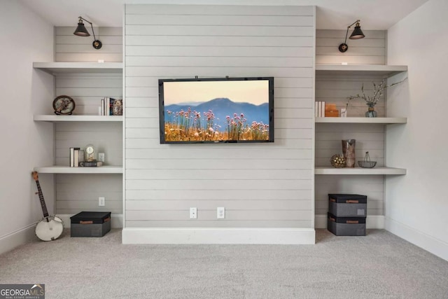 interior space featuring carpet floors, built in shelves, and baseboards