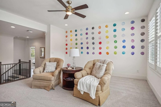 living area with baseboards, a ceiling fan, carpet, an upstairs landing, and recessed lighting