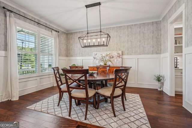 dining area with a wainscoted wall, ornamental molding, a decorative wall, and wood finished floors