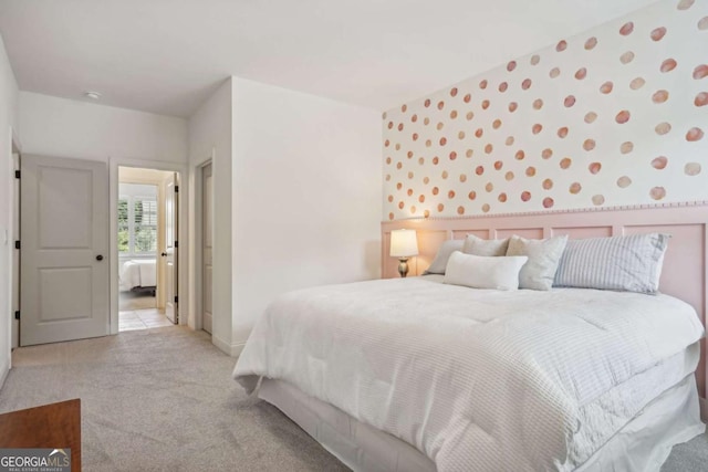 bedroom featuring light carpet and wallpapered walls