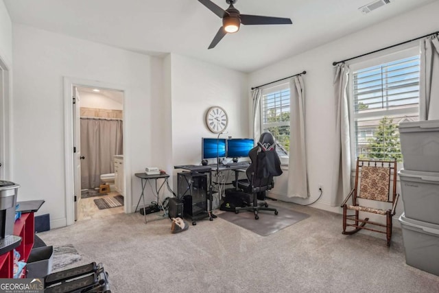 office space featuring carpet, visible vents, ceiling fan, and baseboards