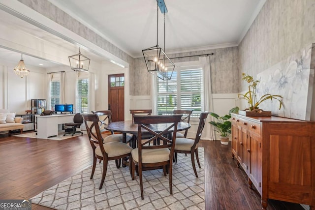 dining area featuring a wainscoted wall, ornamental molding, plenty of natural light, and a notable chandelier