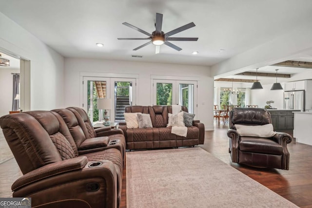 living room with plenty of natural light, visible vents, dark wood-style flooring, and french doors