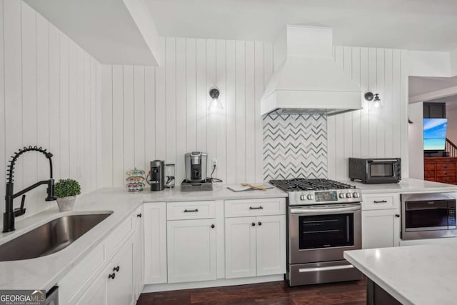 kitchen featuring a toaster, a sink, stainless steel gas range, built in microwave, and premium range hood