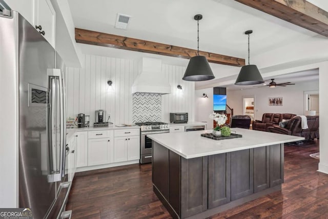 kitchen featuring stainless steel appliances, premium range hood, visible vents, light countertops, and dark wood finished floors