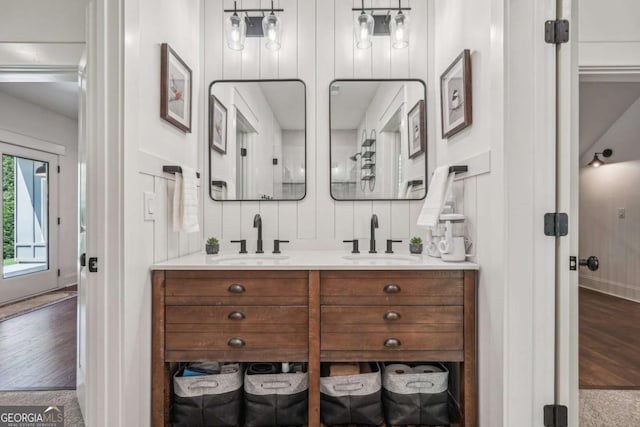 bathroom featuring double vanity, a sink, and wood finished floors