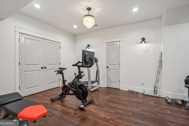 exercise room with recessed lighting, an inviting chandelier, and wood finished floors