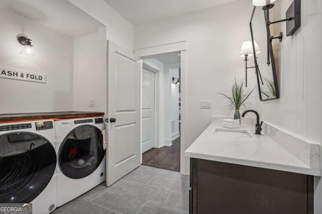 laundry room featuring laundry area, a sink, and separate washer and dryer