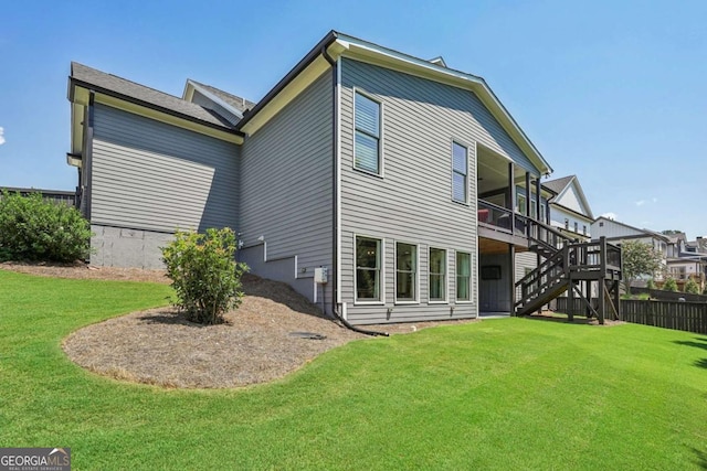 rear view of property featuring stairs, a deck, and a lawn