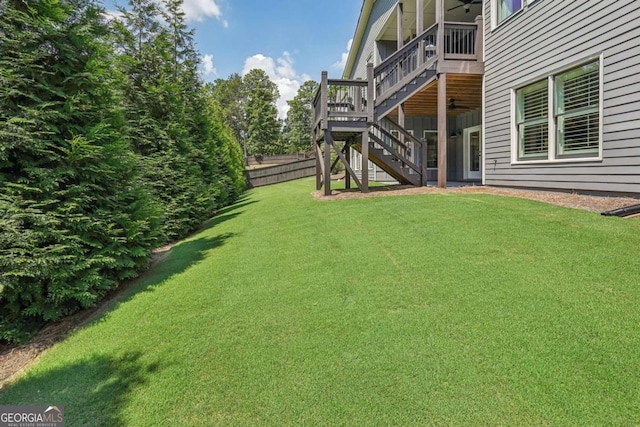 view of yard featuring a ceiling fan and stairs