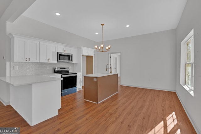 kitchen featuring appliances with stainless steel finishes, light countertops, light wood-style floors, white cabinetry, and a sink