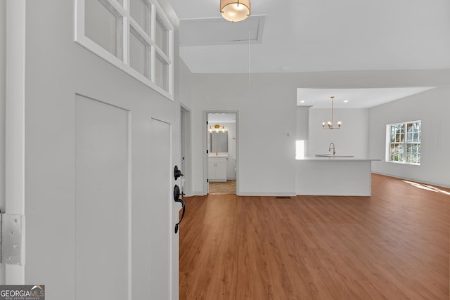 436 Tarpley Ave, Bowdon, GA 30108 - unfurnished living room featuring light wood-style floors, attic access, and a chandelier