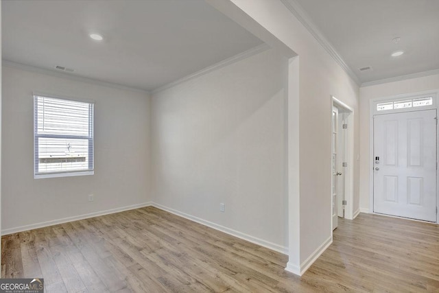 entrance foyer with light wood-type flooring, visible vents, and crown molding