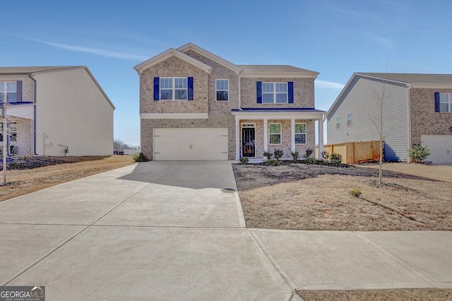 traditional home featuring an attached garage, fence, concrete driveway, and brick siding