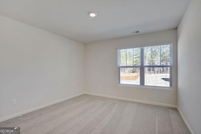 unfurnished room featuring carpet floors, visible vents, and baseboards