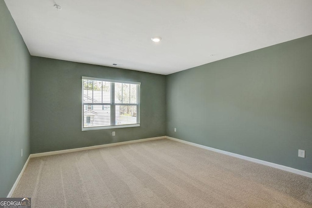 spare room featuring carpet floors and baseboards