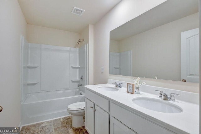 bathroom featuring toilet, double vanity, visible vents, and a sink