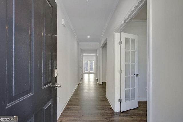 corridor with crown molding, dark wood finished floors, and baseboards