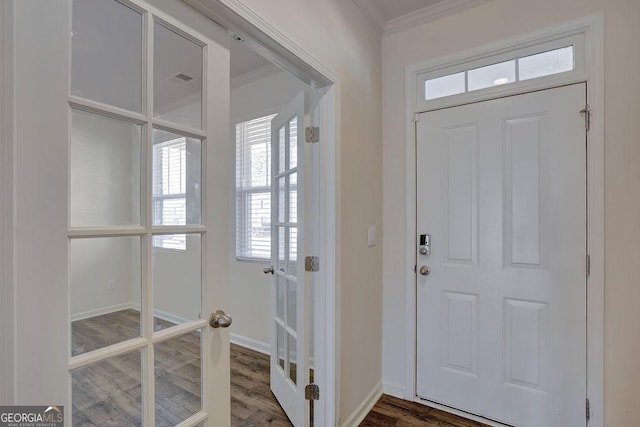 foyer entrance featuring ornamental molding, baseboards, and wood finished floors