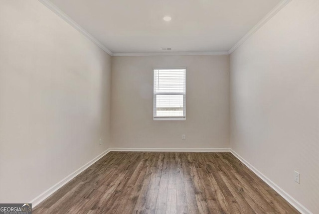 unfurnished room featuring visible vents, baseboards, crown molding, and wood finished floors