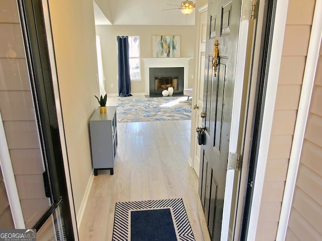 corridor with light wood-style flooring and baseboards