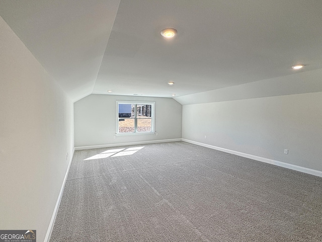 additional living space with vaulted ceiling, carpet, and baseboards