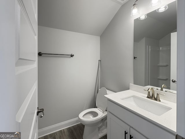 bathroom featuring toilet, wood finished floors, vanity, and lofted ceiling