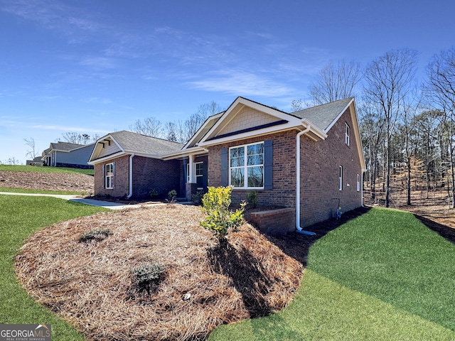 view of front of home with brick siding and a front yard