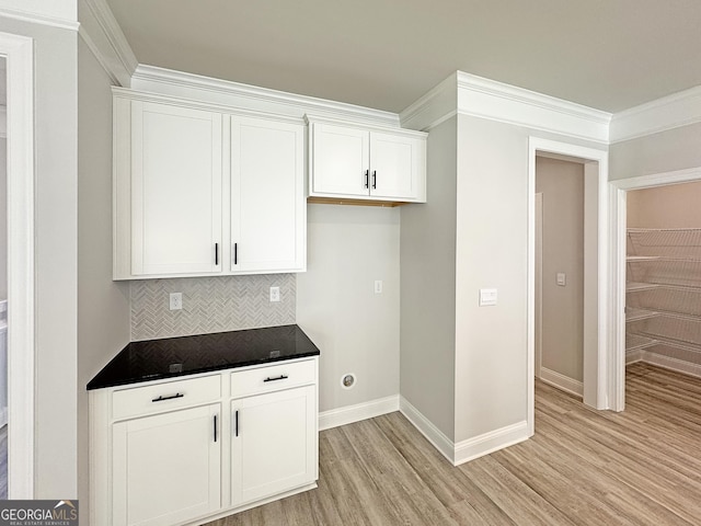 kitchen with baseboards, white cabinets, decorative backsplash, light wood finished floors, and dark countertops