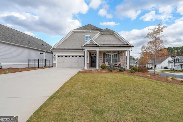 craftsman-style house featuring brick siding, a front yard, a standing seam roof, a garage, and driveway