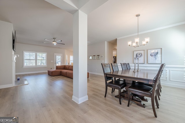 dining room featuring ceiling fan with notable chandelier, ornamental molding, baseboards, and light wood-style floors