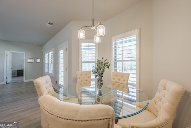 dining room featuring visible vents, baseboards, and wood finished floors