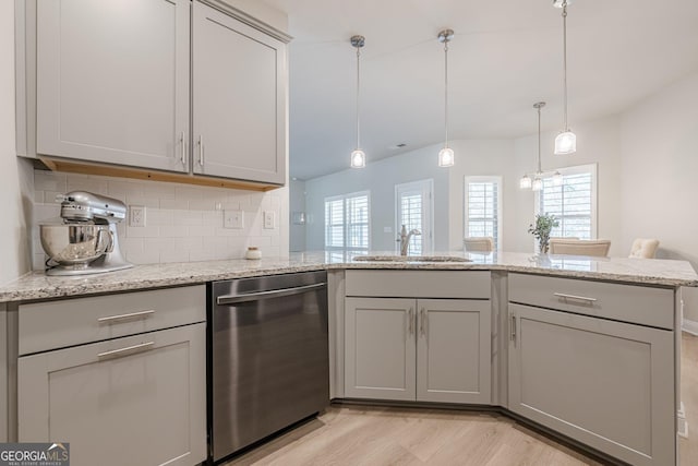 kitchen featuring tasteful backsplash, a peninsula, gray cabinets, stainless steel dishwasher, and a sink