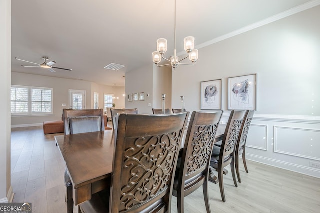 dining room with light wood-style floors, visible vents, ornamental molding, and ceiling fan with notable chandelier