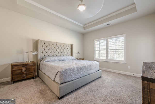 bedroom featuring carpet floors, visible vents, baseboards, ornamental molding, and a tray ceiling