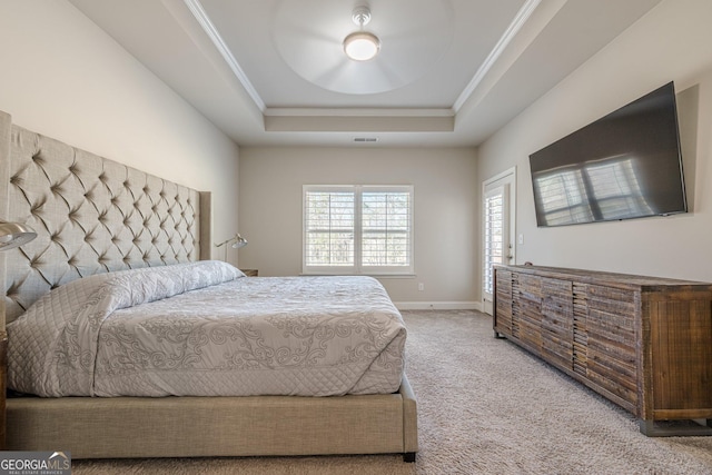 carpeted bedroom featuring baseboards, a tray ceiling, visible vents, and crown molding