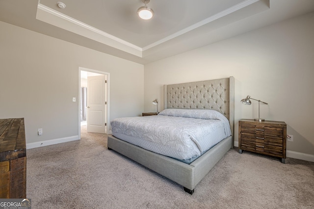 bedroom featuring carpet floors, a raised ceiling, ornamental molding, and baseboards