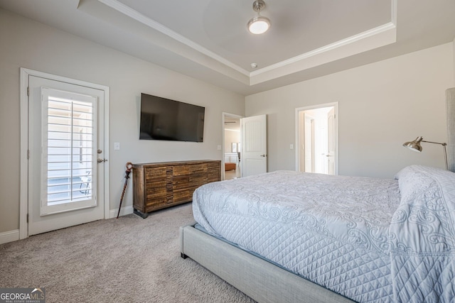 bedroom featuring carpet floors, a raised ceiling, ornamental molding, and baseboards